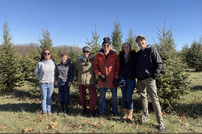 The Starr Pines family standing together in the tree field